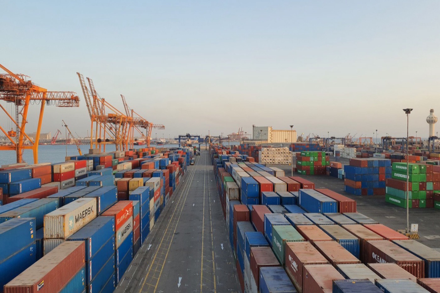 A bustling port scene with colorful cargo containers at sunrise. Ideal for logistics concepts.